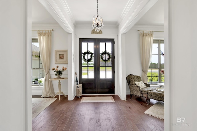 entrance foyer featuring an inviting chandelier, ornamental molding, baseboards, hardwood / wood-style flooring, and french doors