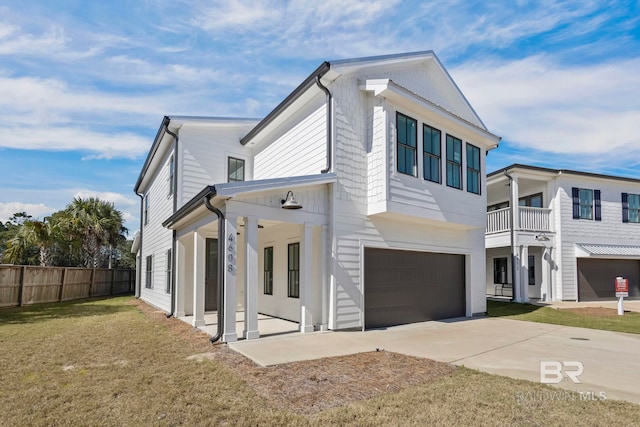 view of front of home featuring driveway, an attached garage, a front yard, and fence