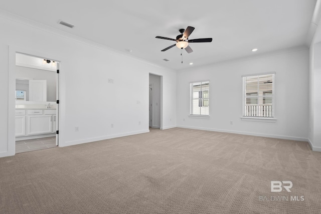 empty room featuring visible vents, baseboards, light colored carpet, and ornamental molding