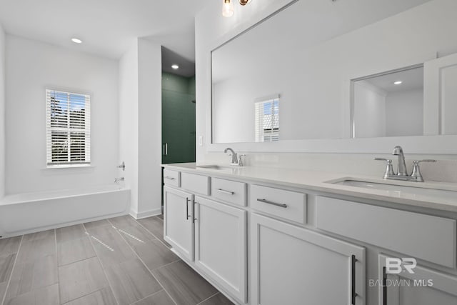 bathroom featuring a healthy amount of sunlight, a stall shower, and a sink