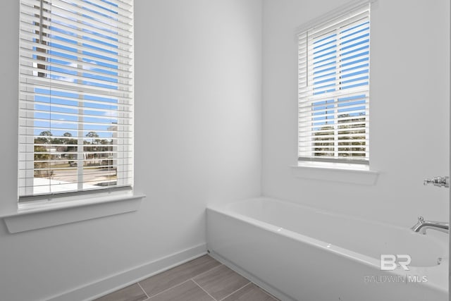 bathroom with baseboards and a garden tub