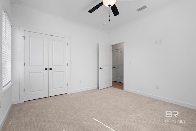 unfurnished bedroom with a closet, visible vents, carpet, and ornamental molding