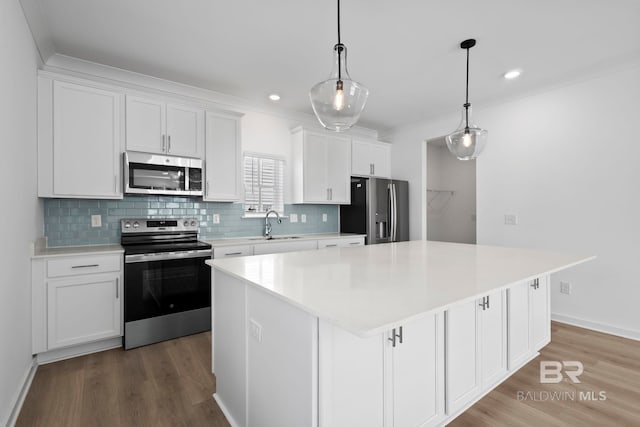 kitchen featuring a sink, a kitchen island, appliances with stainless steel finishes, and white cabinets