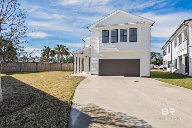 view of front of property with a front lawn, an attached garage, driveway, and fence