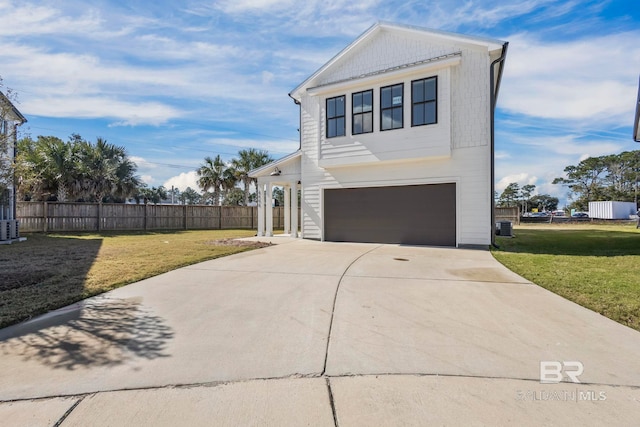 view of front of house featuring a front lawn, an attached garage, and fence