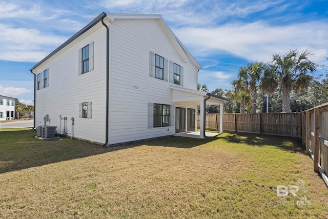 back of property with a yard, central AC, and a fenced backyard