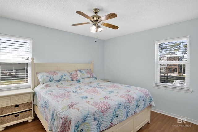 bedroom featuring multiple windows, a textured ceiling, and wood finished floors