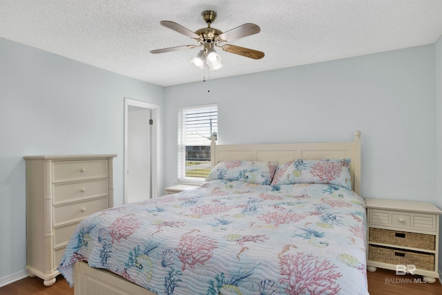 bedroom with ceiling fan, a textured ceiling, and wood finished floors