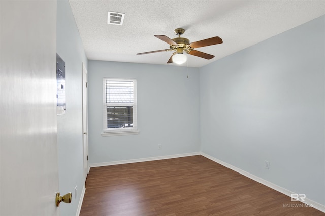 unfurnished room with visible vents, a textured ceiling, baseboards, and wood finished floors