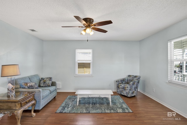 living area featuring wood finished floors, visible vents, and baseboards