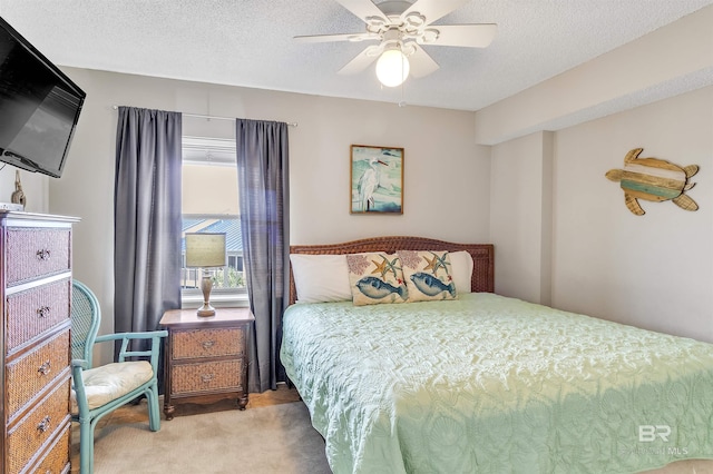 bedroom featuring a textured ceiling, light colored carpet, and ceiling fan