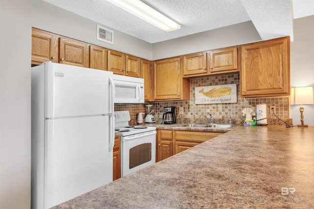 kitchen featuring white appliances, decorative backsplash, sink, and a textured ceiling