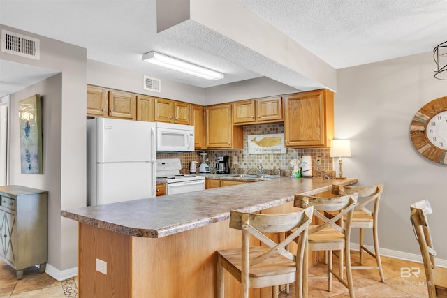 kitchen with a textured ceiling, white appliances, light tile patterned floors, backsplash, and kitchen peninsula