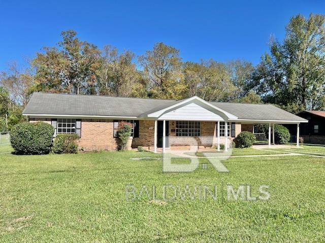 view of front of house with a carport and a front lawn