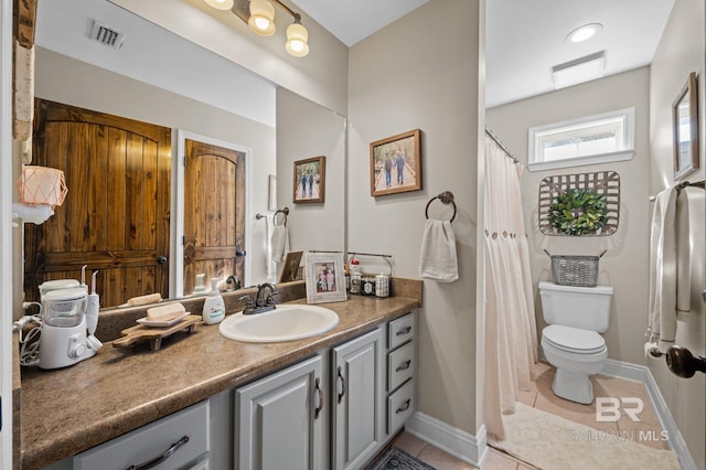 bathroom featuring tile patterned flooring, vanity, and toilet