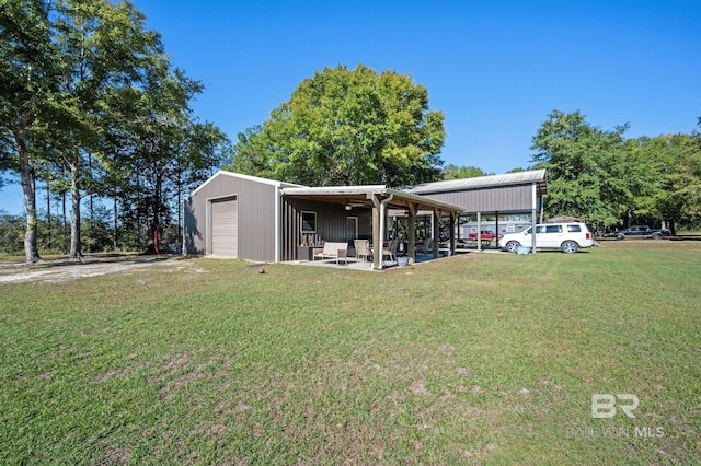 view of front facade with a carport, a garage, a front lawn, and an outdoor structure