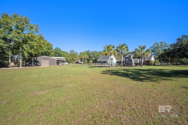 view of yard featuring a garage, an outdoor structure, and a carport