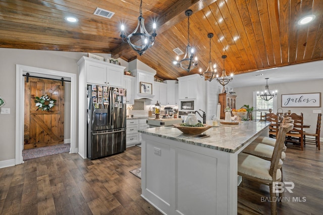 kitchen featuring white cabinets, stainless steel fridge, a spacious island, and pendant lighting