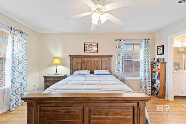 bedroom featuring a textured ceiling, light hardwood / wood-style flooring, and ceiling fan