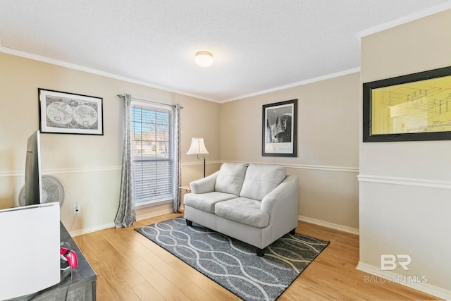 sitting room featuring hardwood / wood-style flooring, crown molding, and a textured ceiling