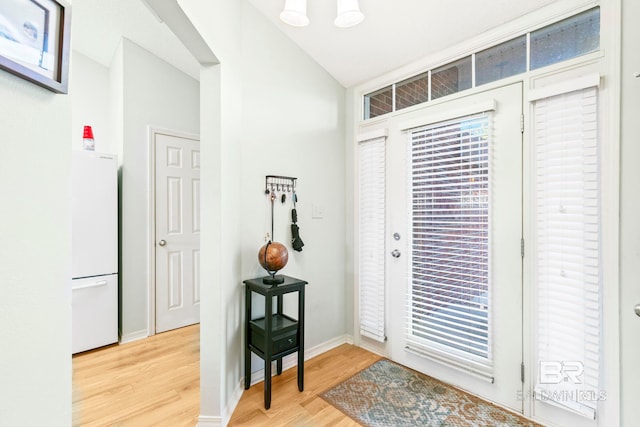 entryway with light wood-type flooring and vaulted ceiling