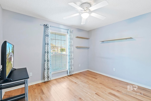 spare room featuring hardwood / wood-style floors, ceiling fan, and a textured ceiling