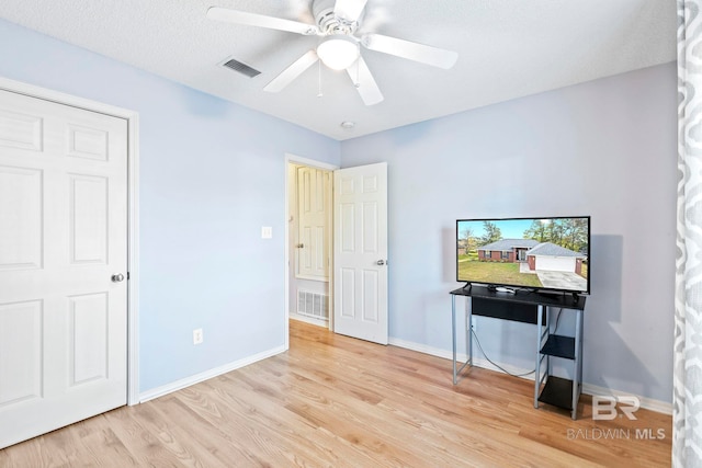 office area with ceiling fan, light hardwood / wood-style floors, and a textured ceiling