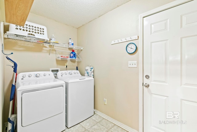 washroom featuring a textured ceiling and washing machine and clothes dryer