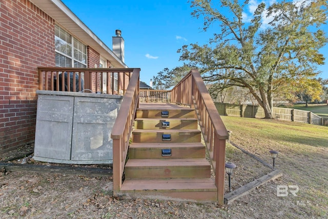 wooden deck featuring a lawn