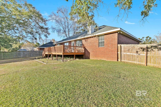 back of property featuring a yard and a wooden deck