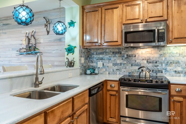 630 Lemoyne Dr Unit 8D, Dauphin Island, AL 36528 - kitchen featuring brown cabinetry, appliances with stainless steel finishes, light countertops, a sink, and backsplash