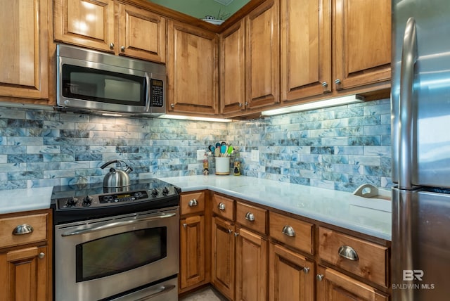 630 Lemoyne Dr Unit 8D, Dauphin Island, AL 36528 - kitchen with tasteful backsplash, brown cabinets, light countertops, and stainless steel appliances