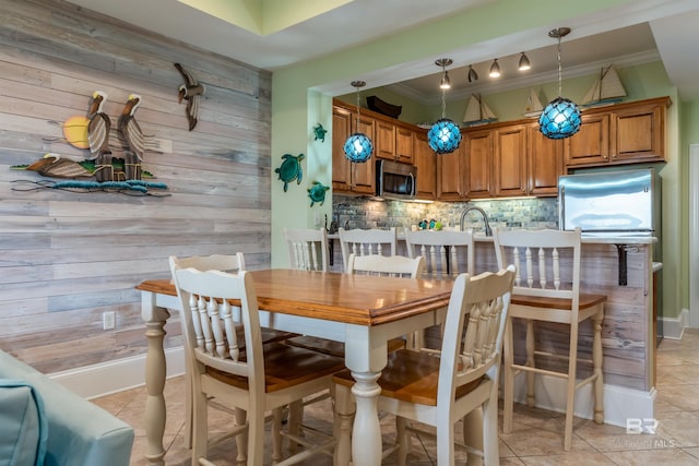 630 Lemoyne Dr Unit 8D, Dauphin Island, AL 36528 - dining area featuring ornamental molding, wood walls, and light tile patterned floors