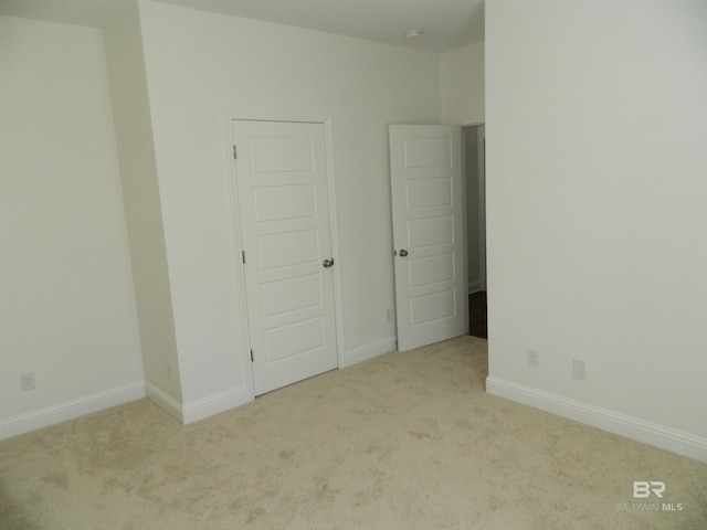 unfurnished bedroom featuring light carpet