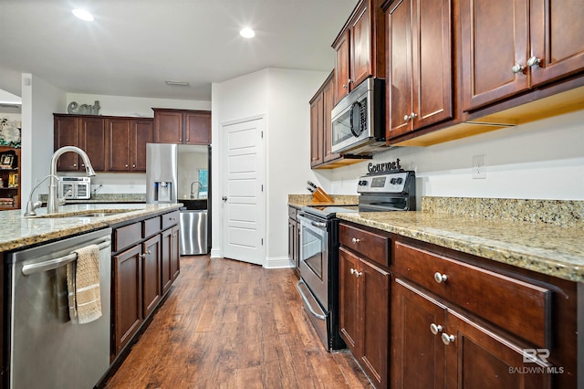 kitchen featuring light stone countertops, dark wood-type flooring, stainless steel appliances, and sink