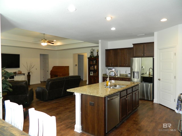 kitchen featuring light stone counters, sink, an island with sink, and stainless steel appliances