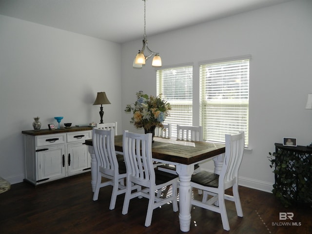 dining space featuring dark hardwood / wood-style floors and a chandelier