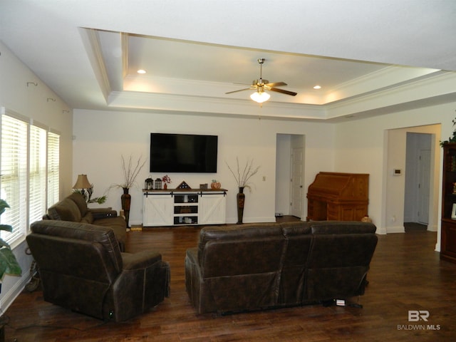 living room with a tray ceiling, ceiling fan, crown molding, and dark hardwood / wood-style floors