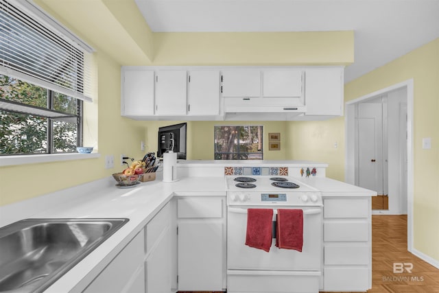2277 Oyster Bay Ln Unit 502, Gulf Shores, AL 36542 - kitchen with white cabinets, a peninsula, light countertops, and electric range