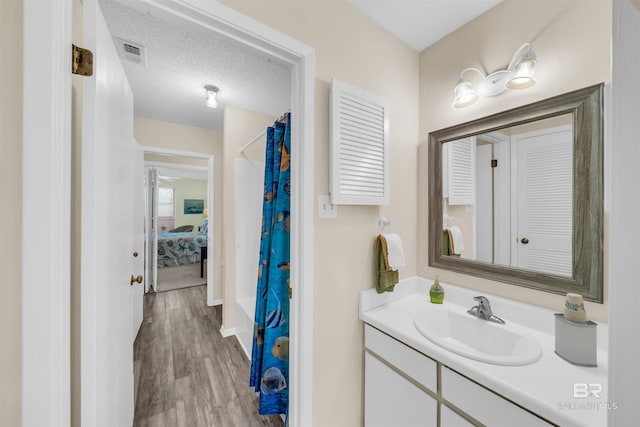 2277 Oyster Bay Ln Unit 502, Gulf Shores, AL 36542 - ensuite bathroom with ensuite bathroom, vanity, a shower with curtain, visible vents, and wood finished floors
