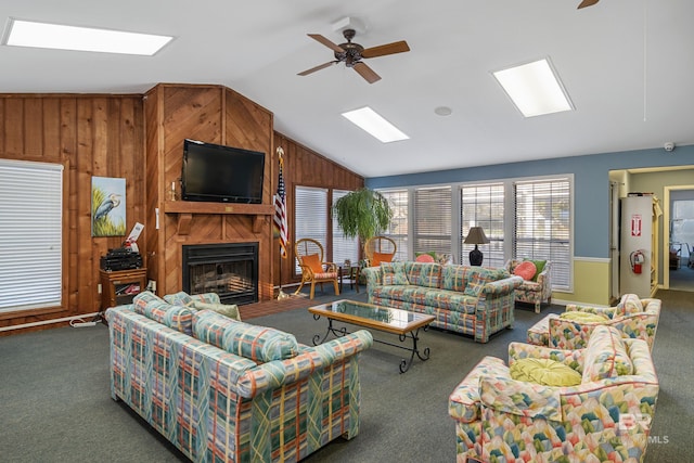 2277 Oyster Bay Ln Unit 502, Gulf Shores, AL 36542 - carpeted living room featuring wood walls, ceiling fan, vaulted ceiling, and a fireplace