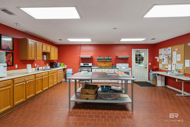 2277 Oyster Bay Ln Unit 502, Gulf Shores, AL 36542 - kitchen with visible vents, a sink, light countertops, white appliances, and brown cabinets
