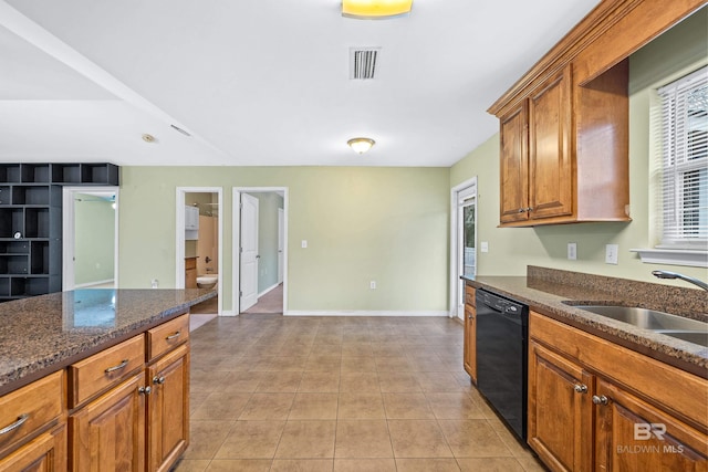 kitchen with dishwasher, sink, light tile patterned floors, and dark stone counters