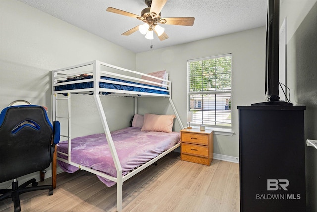 9340 Burnt Tree Dr, Mobile, AL 36695 - bedroom with light wood finished floors, ceiling fan, baseboards, and a textured ceiling