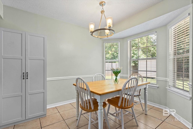 9340 Burnt Tree Dr, Mobile, AL 36695 - dining room featuring light tile patterned floors, a chandelier, a textured ceiling, and baseboards