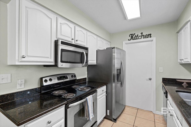 9340 Burnt Tree Dr, Mobile, AL 36695 - kitchen featuring stainless steel appliances, white cabinets, dark stone countertops, light tile patterned flooring, and a sink