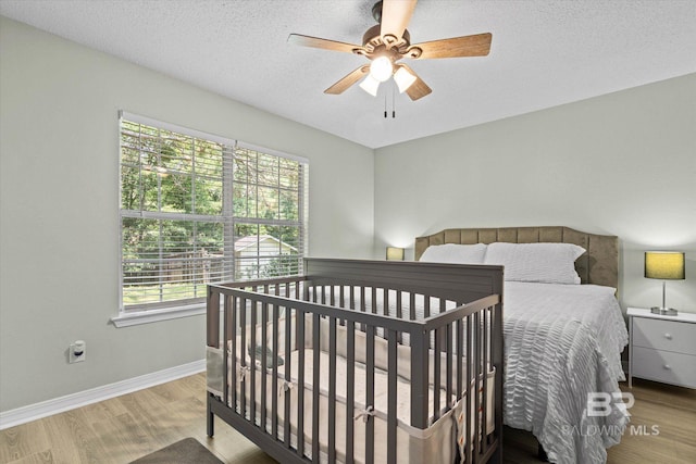 9340 Burnt Tree Dr, Mobile, AL 36695 - bedroom featuring wood finished floors, baseboards, a ceiling fan, and a textured ceiling