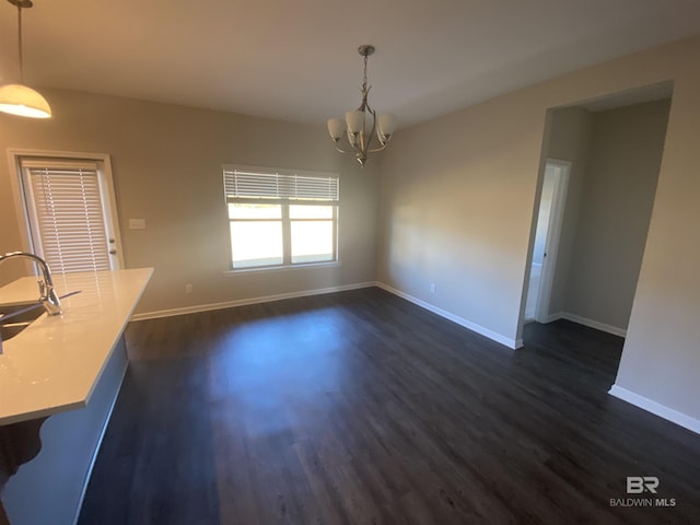 unfurnished dining area with a notable chandelier, dark hardwood / wood-style flooring, and sink