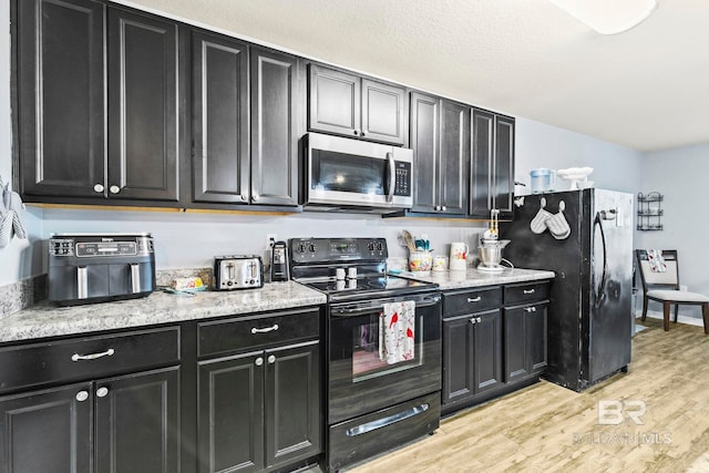 kitchen featuring light hardwood / wood-style flooring and black appliances