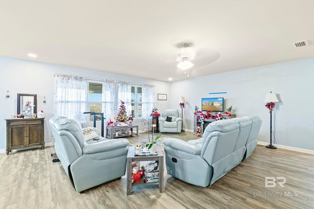 living room featuring ceiling fan and light hardwood / wood-style floors